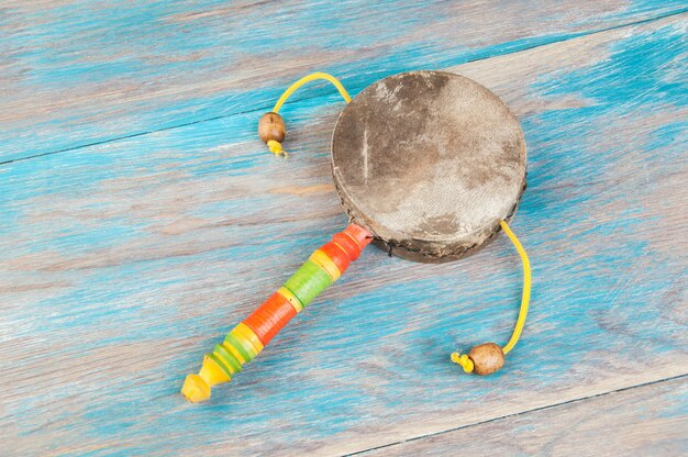 Foto tambor de mano marroquí vintage para niños sobre fondo de madera azul.