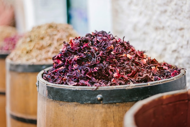 Tambores de madeira grandes cheios de especiarias diferentes no mercado para a venda.