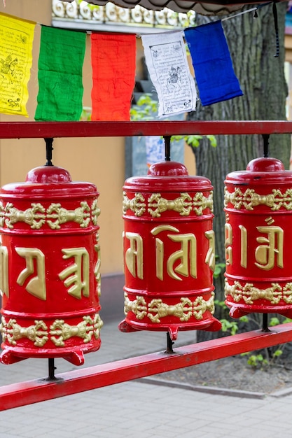 Tambores de oración rojos Khurde con mantras en la calle cerca del templo budista de Buryat datsan