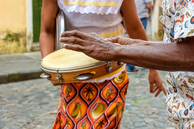 Tamburinist mit einer tanzenden Frau auf der Straße des Bezirks Pelourinho in Salvador Bahia