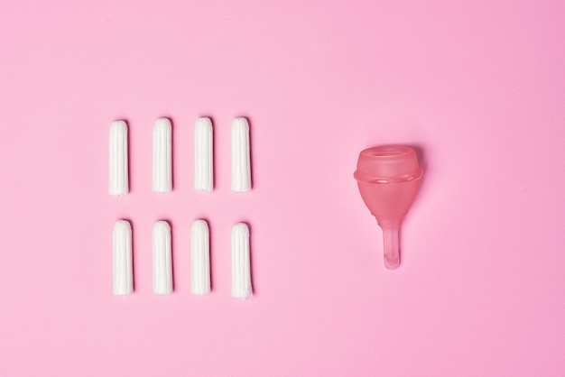 Tampão higiênico feminino para menstruação, copo menstrual em fundo rosa