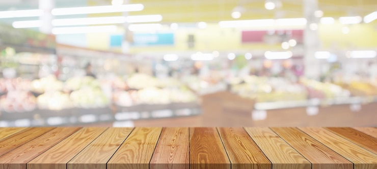Foto tampo da mesa de madeira com fundo desfocado da mercearia do supermercado com luz bokeh para exibição do produto