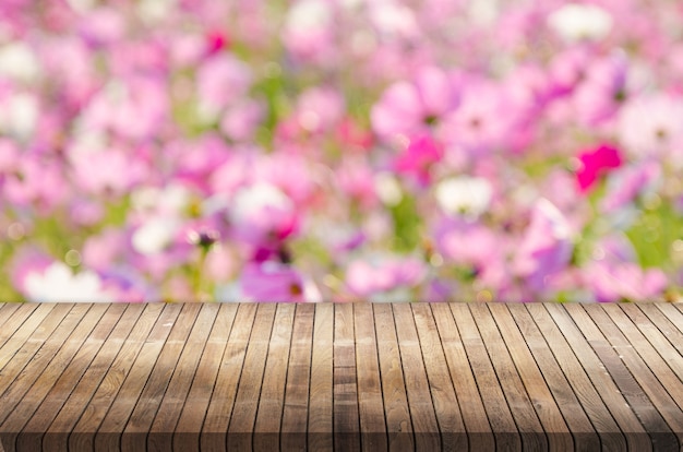 Tampo da mesa de madeira sobre fundo de bokeh flor rosa