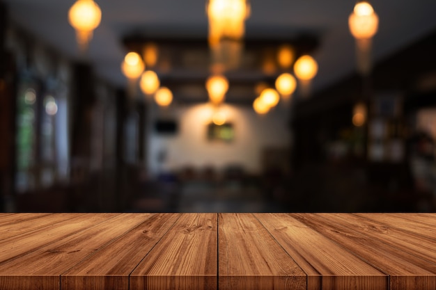 Tampo da mesa de madeira vazio com café turva ou fundo interior do restaurante. pode ser usado o display do produto.