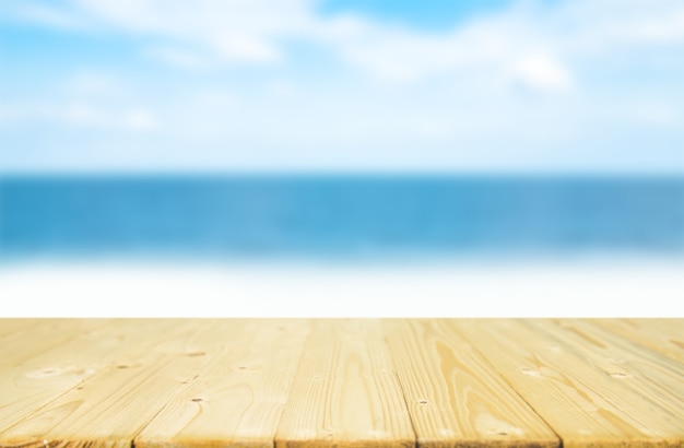 Tampo da mesa de madeira vazio da prancha com o céu azul e o mar do borrão.