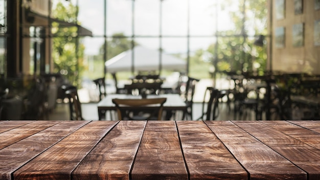 Tampo da mesa de madeira vazio e fundo interior desfocado do café e do restaurante - pode ser usado para exibir ou montar seus produtos.