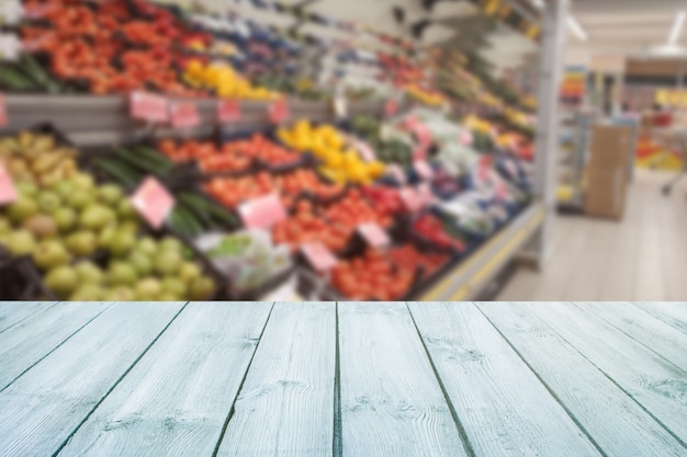 Foto tampo da mesa de madeira vazio no fruto borrado do mercado, loja.