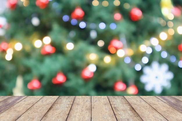 Tampo de mesa de madeira vazio com borrão abstrato árvore de natal com luz de fundo de bokeh de decoração para exibição de produtos