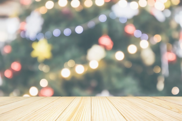 Tampo de mesa de madeira vazio com borrão abstrato Árvore de Natal com luz de fundo de bokeh de decoração para exibição de produto