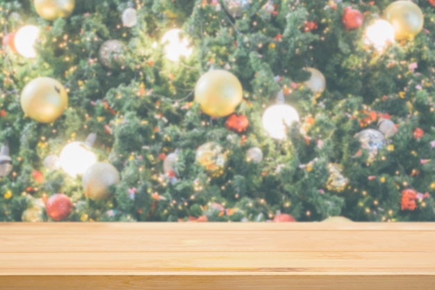 Tampo de mesa de madeira vazio com borrão abstrato Árvore de Natal com luz de fundo de bokeh de decoração para exibição de produto