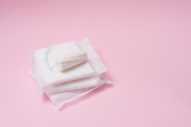 Foto tampón menstrual y almohadillas en un rosa. tiempo de menstruación. higiene y protección. copyspace