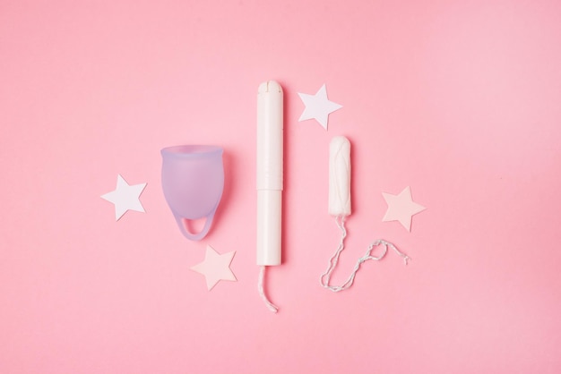 Tampones de copa menstrual sobre fondo rosa La vista es plana Concepto de menstruación de días críticos