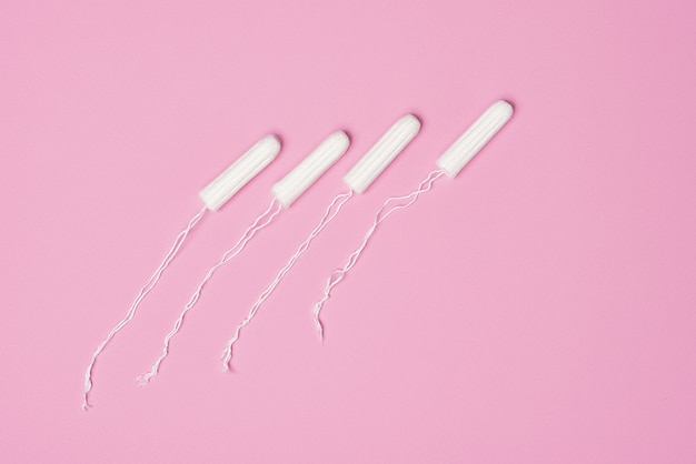 Foto tampones femeninos higiénicos para la menstruación sobre fondo rosa