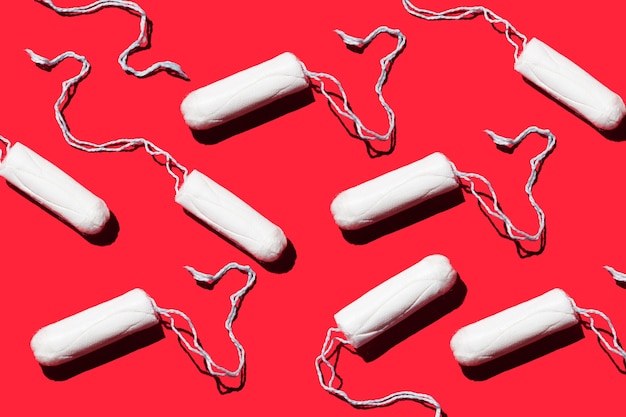 Tampones de higiene femenina sobre un fondo rojo Concepto de menstruación