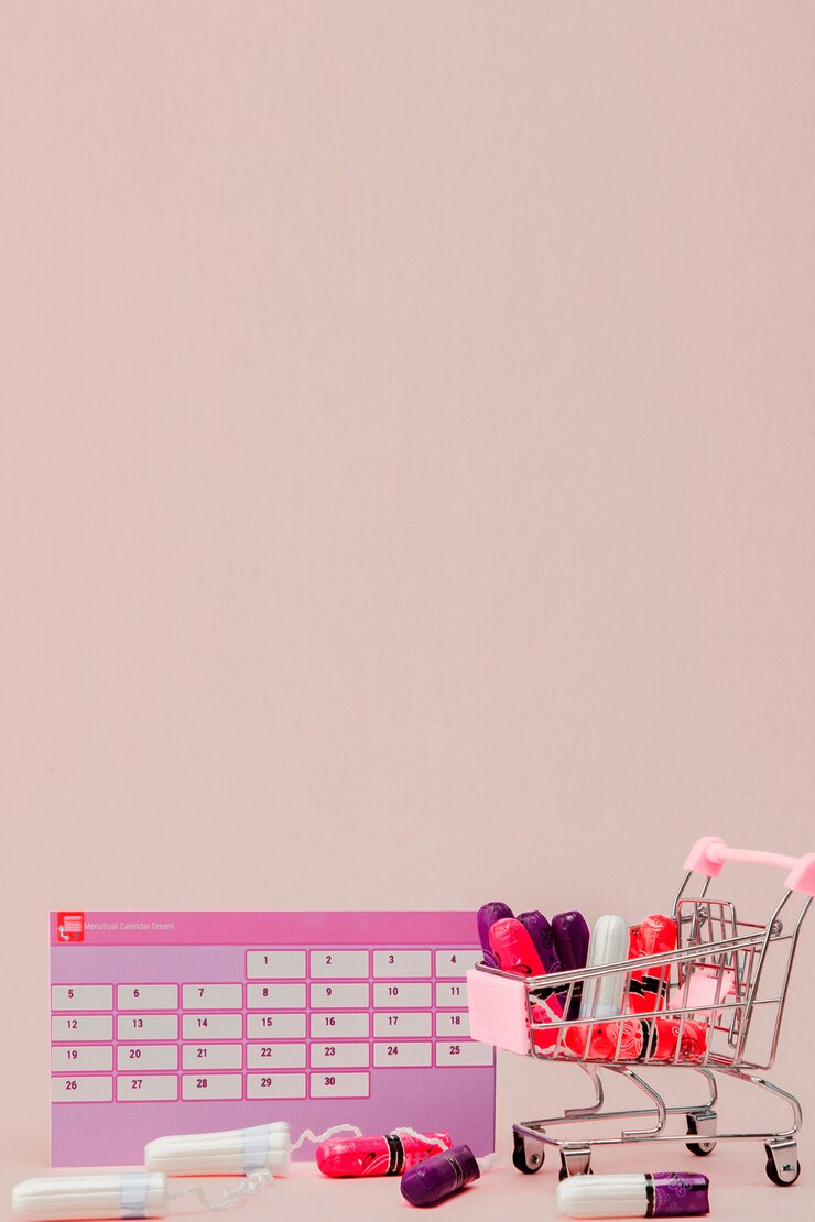Foto tampones, toallas sanitarias femeninas para días críticos, calendario femenino, analgésicos durante la menstruación en una pared rosa. seguimiento del ciclo menstrual y la ovulación