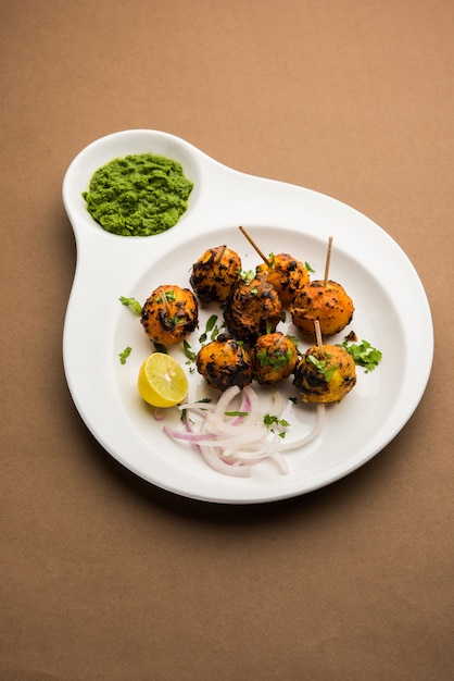 Tandoori aloo são batatas assadas com especiarias indianas. É um aperitivo de festa servido com chutney verde. foco seletivo