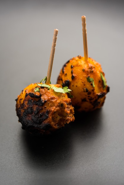 Tandoori aloo são batatas assadas com especiarias indianas. É um aperitivo de festa servido com chutney verde. foco seletivo