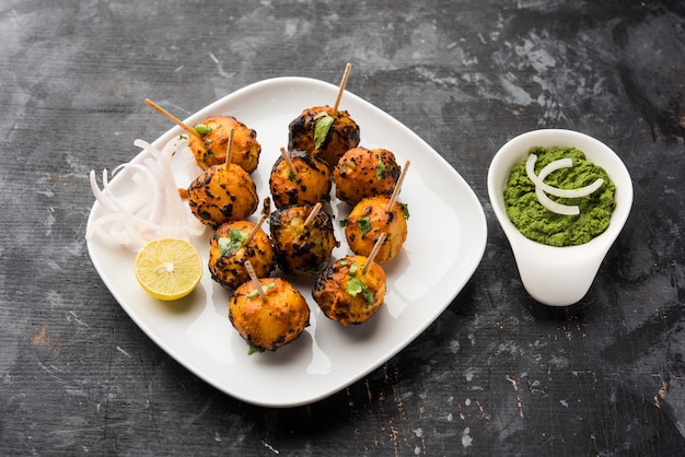 Tandoori Aloo sind Bratkartoffeln mit indischen Gewürzen. Es ist eine Party-Vorspeise, serviert mit grünem Chutney. selektiver Fokus