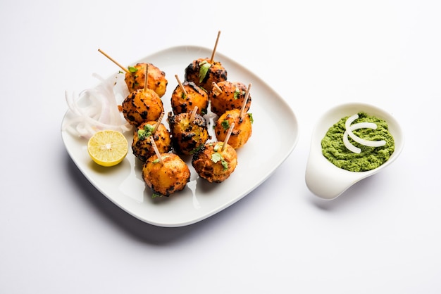 Tandoori Aloo sind Bratkartoffeln mit indischen Gewürzen. Es ist eine Party-Vorspeise, serviert mit grünem Chutney. selektiver Fokus