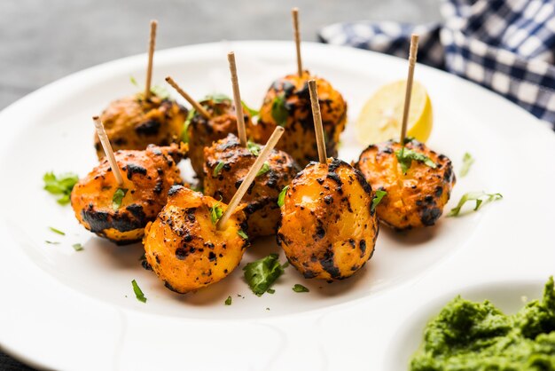 Tandoori aloo son patatas asadas con especias indias. Es un aperitivo de fiesta servido con chutney verde. enfoque selectivo