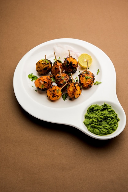 Tandoori aloo son patatas asadas con especias indias. Es un aperitivo de fiesta servido con chutney verde. enfoque selectivo