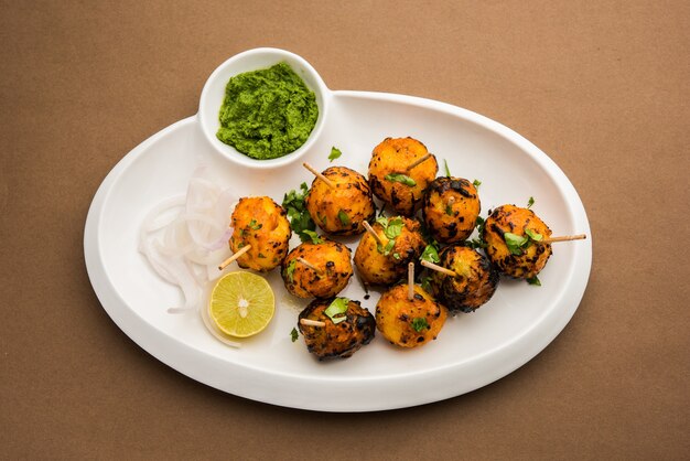 Tandoori aloo son patatas asadas con especias indias. Es un aperitivo de fiesta servido con chutney verde. enfoque selectivo