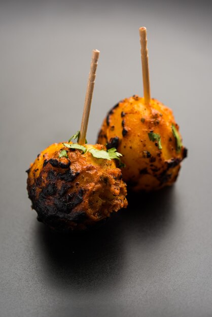 Tandoori aloo son patatas asadas con especias indias. Es un aperitivo de fiesta servido con chutney verde. enfoque selectivo