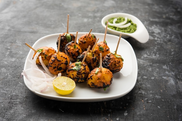 Tandoori aloo son patatas asadas con especias indias. Es un aperitivo de fiesta servido con chutney verde. enfoque selectivo