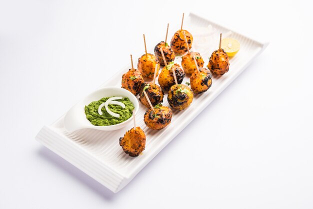 Tandoori aloo son patatas asadas con especias indias. Es un aperitivo de fiesta servido con chutney verde. enfoque selectivo