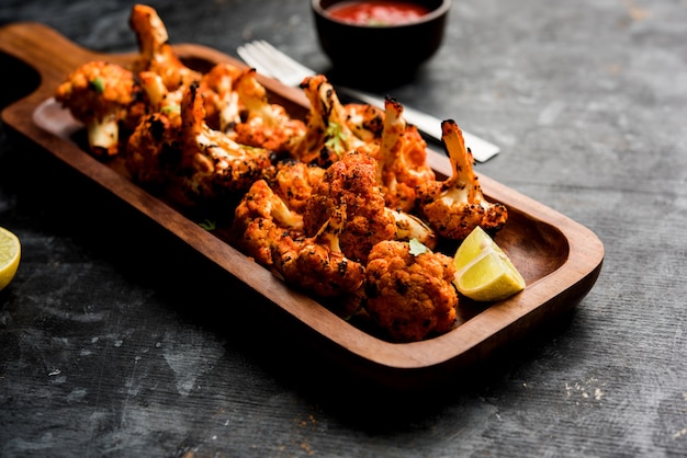 Tandoori Gobi o coliflor asada Tikka es un plato seco elaborado asando coliflores en Oven, Tandoor. Es un plato popular de la India. servido con salsa de tomate. enfoque selectivo