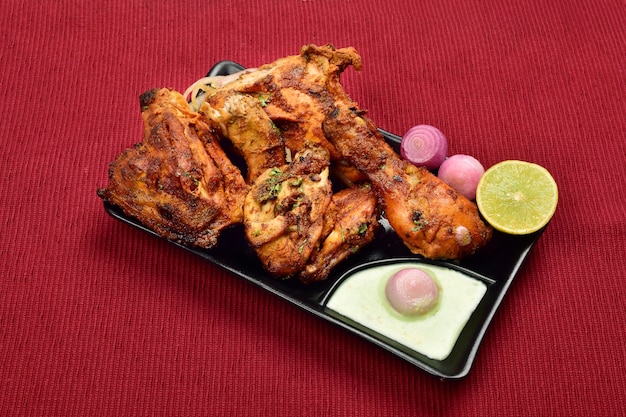 Tandoori-Huhn, serviert mit Chutney Pyaz im Teller