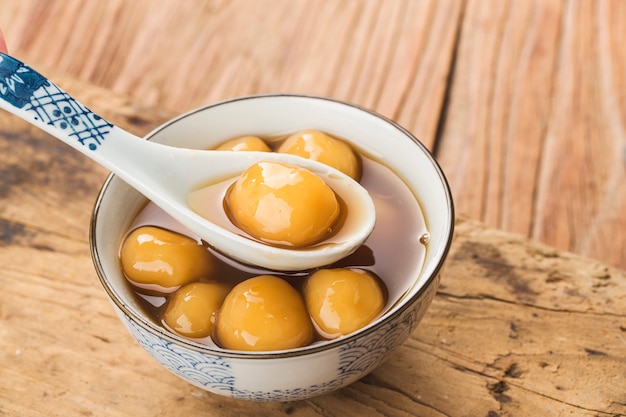 Tang Yuan (albóndigas dulces) hechas de glutinoso relleno de sésamo negro en almíbar de jengibre. Cocina tradicional para el festival de los faroles, el festival de mediados de otoño, el dongzhi (solsticio de invierno) y el año nuevo chino.