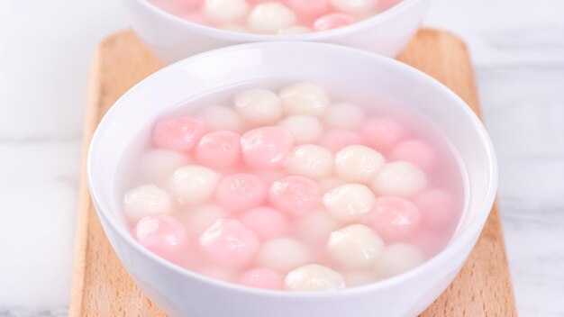 Tang Yuan Tangyuan köstliche rote und weiße Reisknödelbällchen in einer kleinen Schüssel Asiatisches traditionelles festliches Essen für das chinesische Wintersonnenwendefest aus nächster Nähe