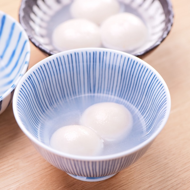 Tang yuan, tangyuan, yuanxiao en un tazón pequeño. Deliciosas bolas de bola de masa de arroz de comida festiva tradicional asiática con rellenos rellenos para el Festival de los Faroles chinos, de cerca.