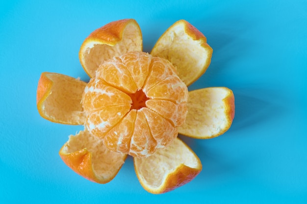 Foto tangerina descascada ou flor de tangerina em forma de superfície ciano