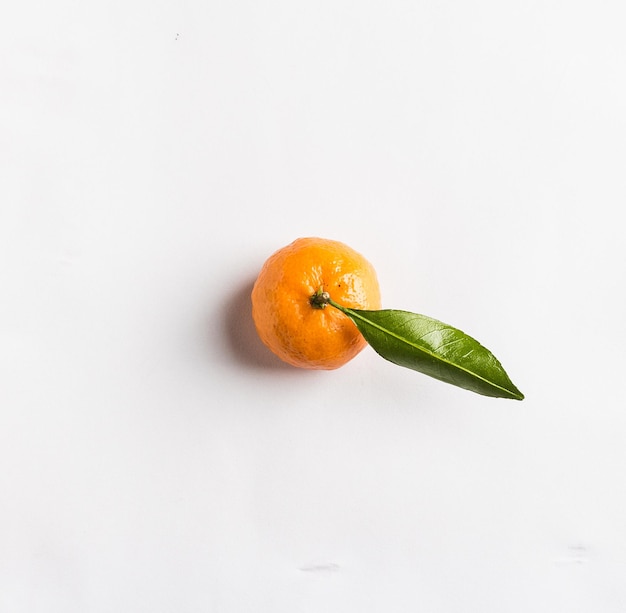 Tangerina isolada com folha verde no fundo branco