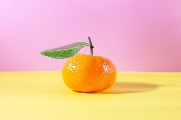 Tangerina madura laranja com folha rosa e amarela