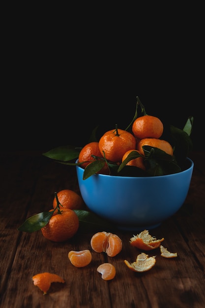 Tangerinas de cereja em uma tigela sobre uma mesa de madeira.