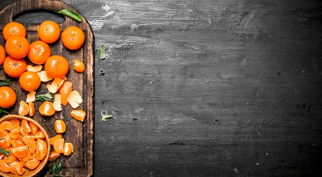 Tangerinas descascadas com folhas verdes.