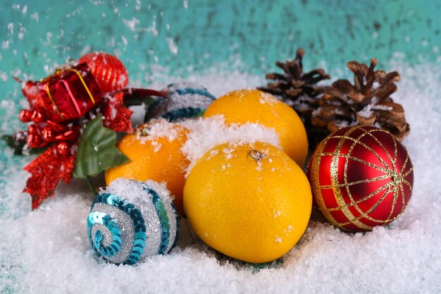 Tangerinas e brinquedos de Natal na mesa de madeira na neve