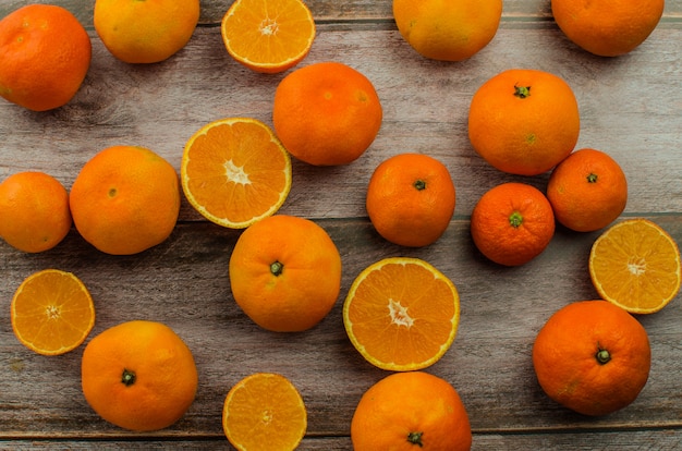 Tangerinas e meias tangerinas na mesa de madeira