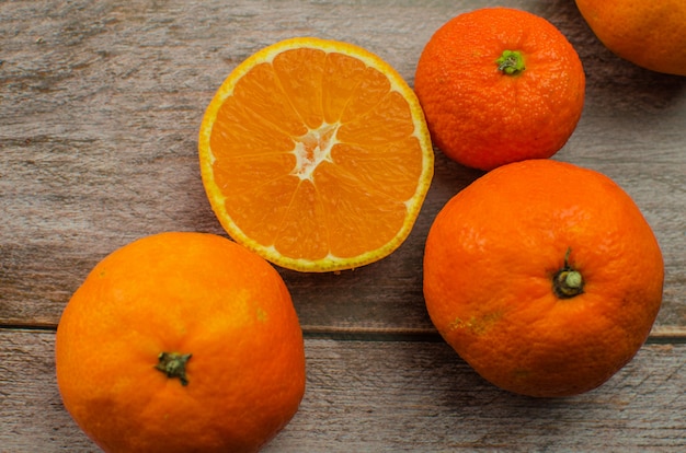 Tangerinas e meias tangerinas na mesa de madeira