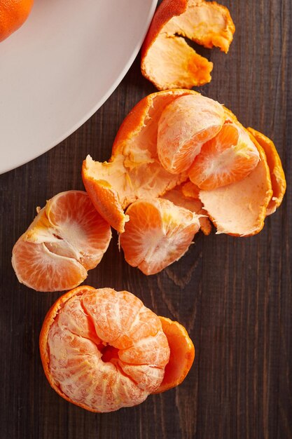 Foto tangerinas em chapa branca sobre fundo de madeira