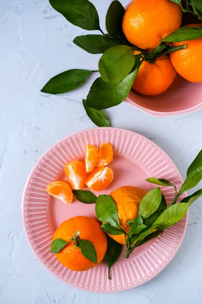 Foto tangerinas em tigelas na superfície cinza