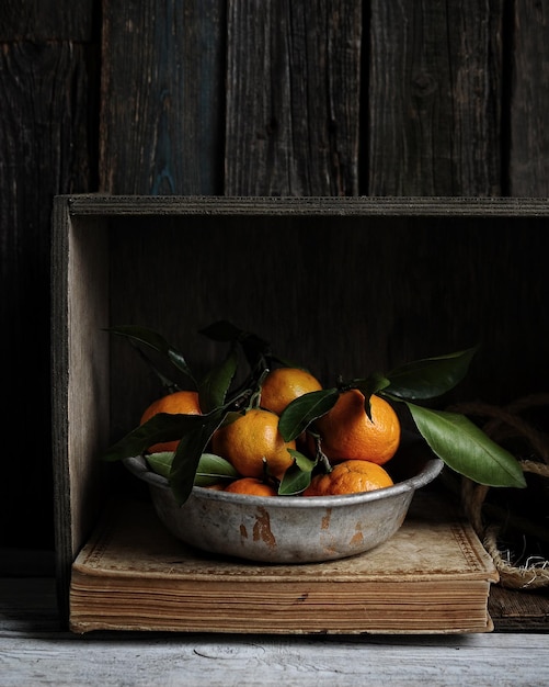 tangerinas frescas com folhas em fundo escuro de tábuas de madeira.