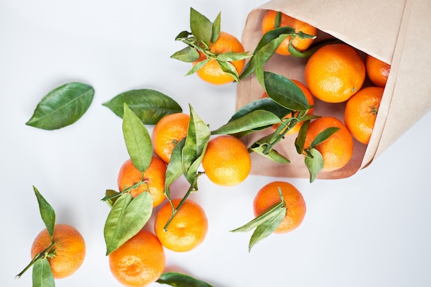 Tangerinas frescas com folhas verdes em um saco de papel