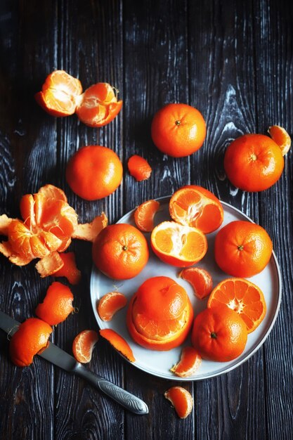 Tangerinas frescas em um fundo escuro de madeira Citrus