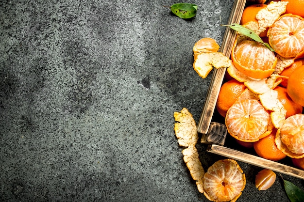 Tangerinas frescas em uma velha caixa na mesa rústica.