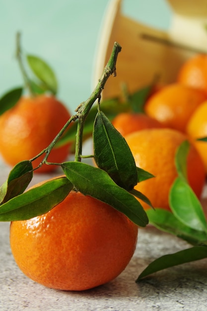 Tangerinas frescas perfumadas com folhas verdes em cima da mesa. Tangerinas maduras e suculentas.