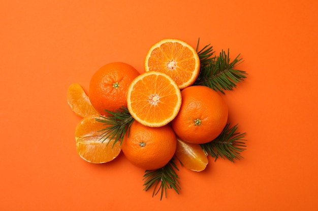 Tangerinas maduras e ramos de pinheiro em laranja